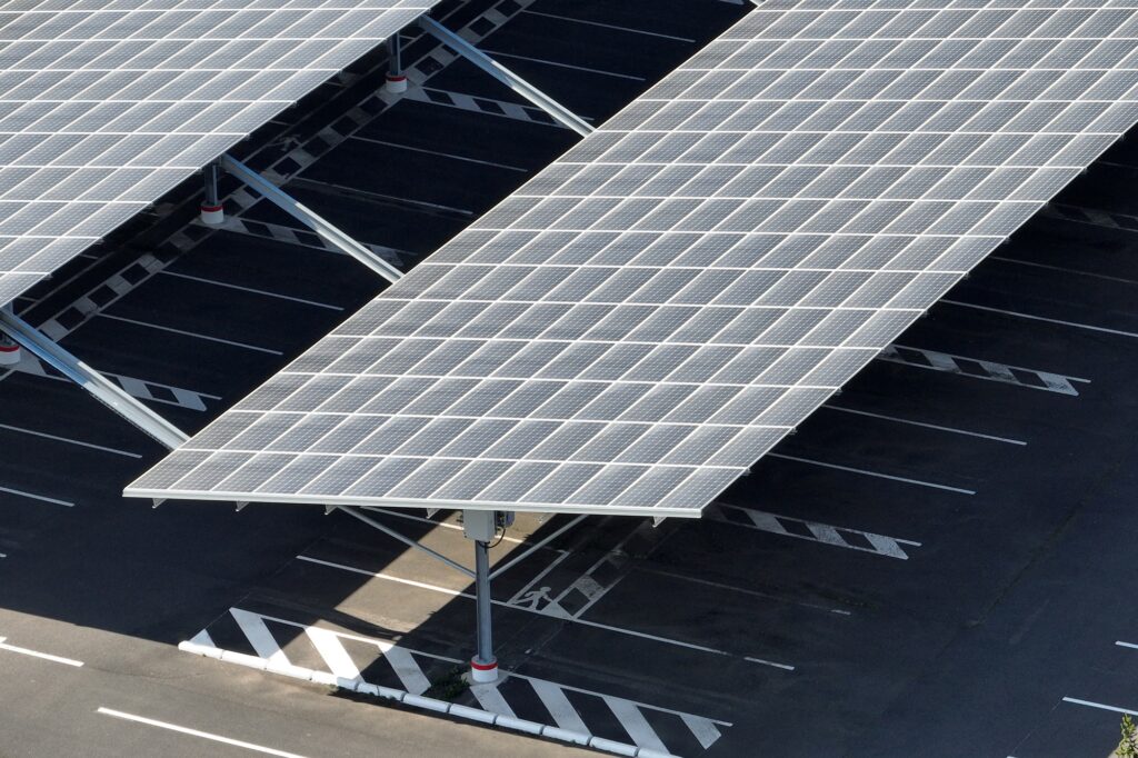 Aerial view of solar panels installed over parking lot with parked cars