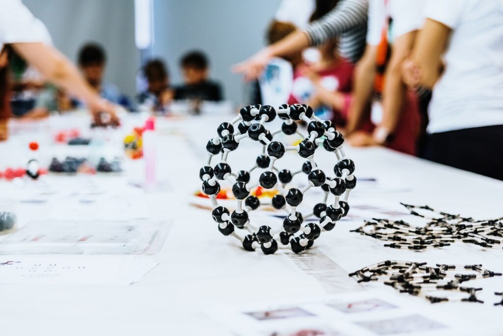 Group of students in biology class creating molecular models with educational toys.